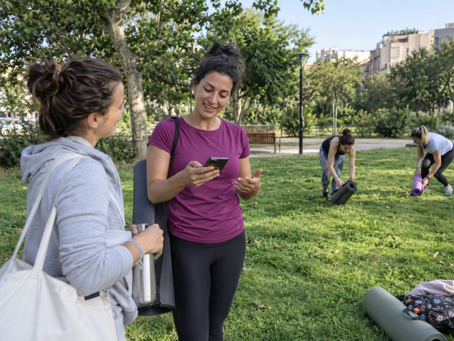 A teacher checks her phone after an outdoor yoga class.